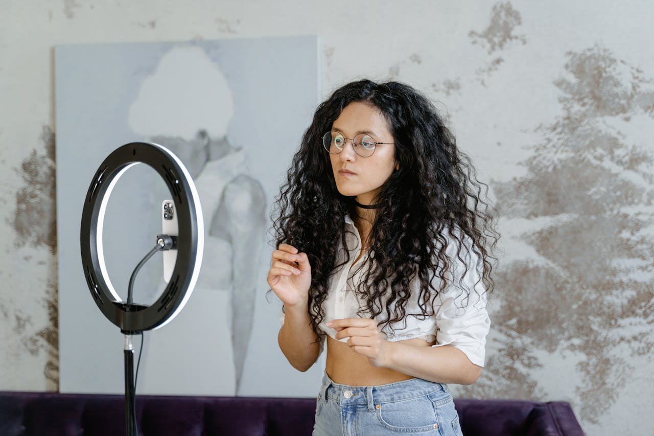 Woman in White Shirt and Blue Denim Shorts Standing Near Ring Light